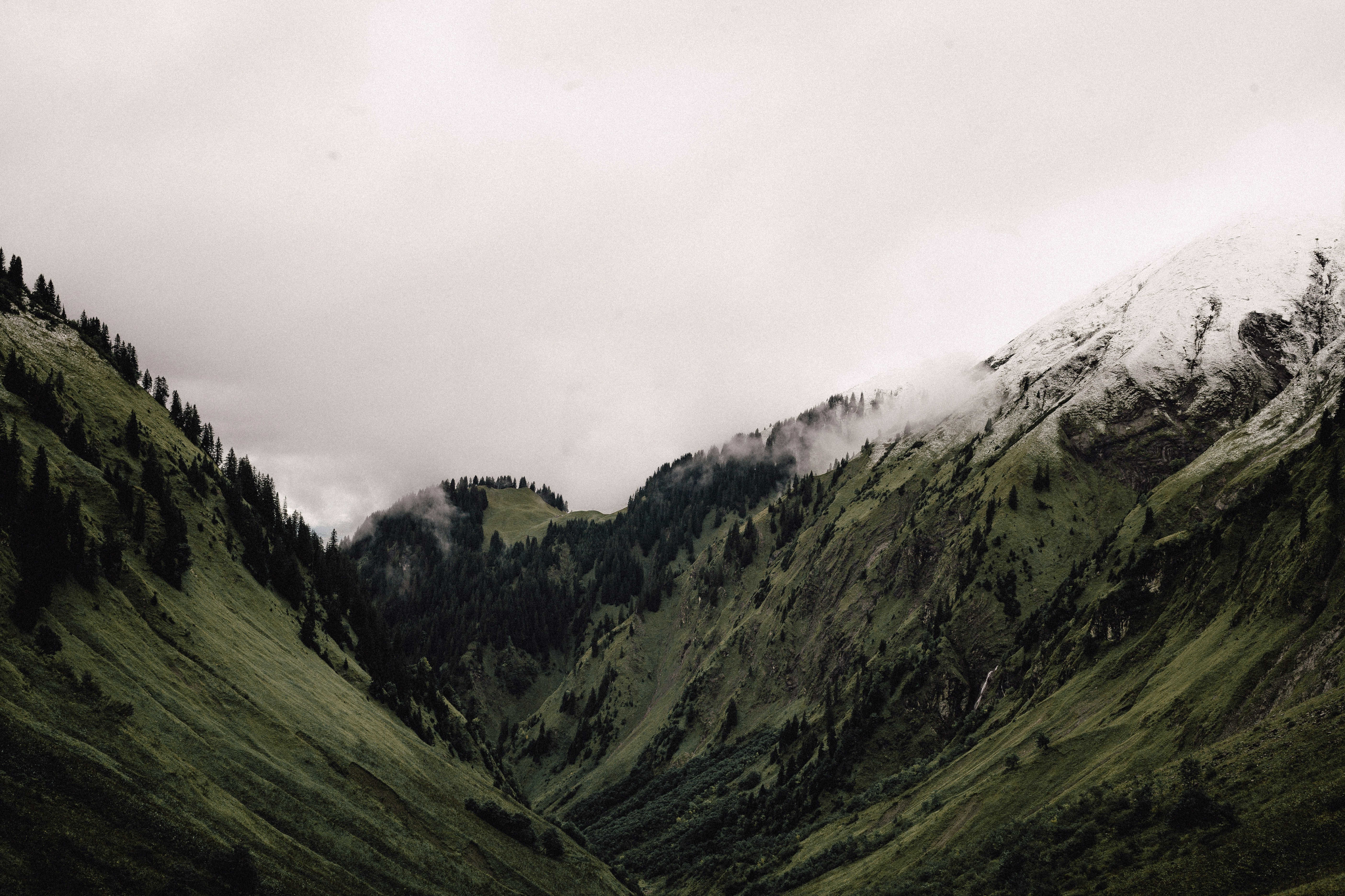 Atmospheric mountain valley with misty peaks